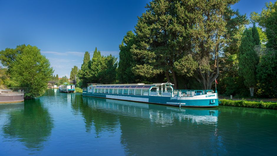 Activités à Béziers – Canal du Midi Canal du Midi à Béziers avec péniches sous un ciel bleu