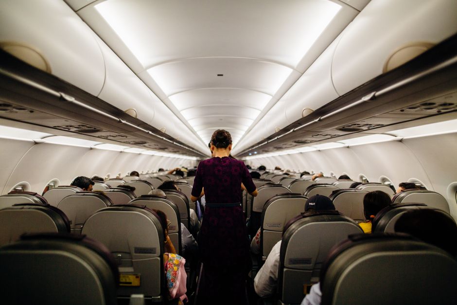 salaire hotesse de lair cabine Hôtesse de l'air marchant dans l'allée d'un avion pendant le service en cabine
