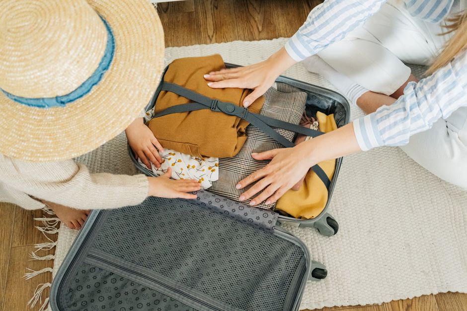 calendrier scolaire valise vacances Une mรจre et son enfant prรฉparent une valise avant le dรฉpart en vacances scolaires