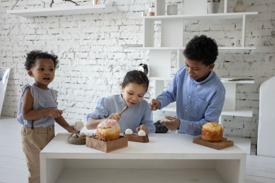 calendrier vacances paques enfants oeufs Trois enfants qui décorent des œufs de Pâques à la maison