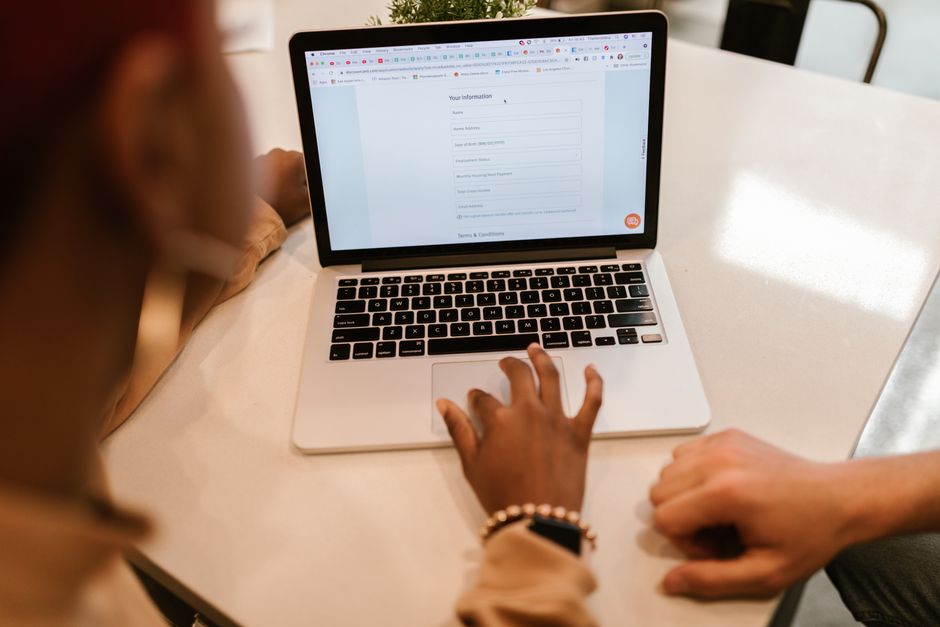 demarches administratives en ligne formulaire Deux personnes remplissant un formulaire administratif en ligne sur un ordinateur portable